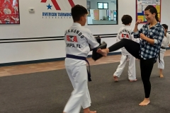 Mom works on kicking the targets while her son holds!