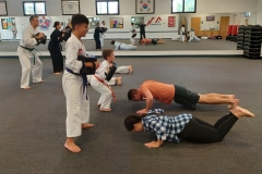 Target holders work on squats while their partners focus on push-ups during a KFMA cardio drill in family class!