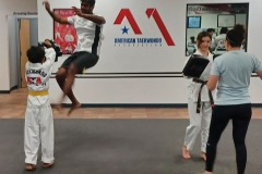 Dad works on trying a double jump front kick while his son holds the targets during the cardio round!