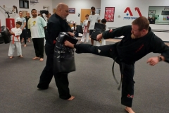 Chief Master DK and one of our High Rank Black Belts demonstrate a side kick drill for the parents trying class. 