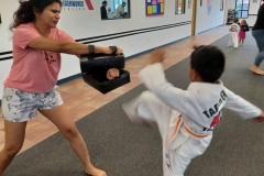 Mom holds the targets while her son works on his front kick! 