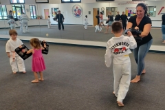 Mom holds the targets for her son, while little sister holds the targets for her older brother! 