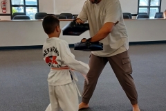Dad holds the targets while his son works on a kicking drill!