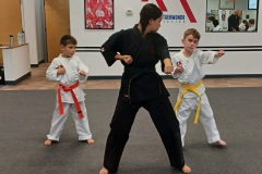 A KFMA Black Belt teen assisting the low-rank kids with their traditional Songahm Taekwondo form. 