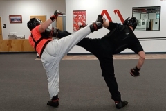 The front leg side kick is the perfect defense against a back leg round kick, as demonstrated by two Adult Black Belts.