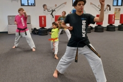 Black Belt Teens assisting in the KFMA Family class working with Low Rank Kids on Taekwondo Forms.