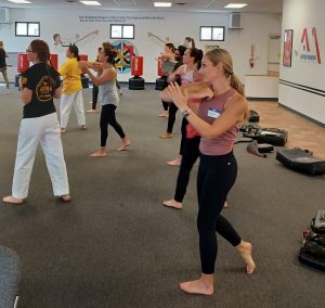 Women and teens practicing elbow strikes at KFMA Women's self-defense seminar