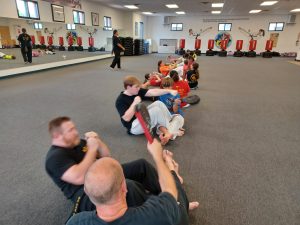 KFMA Improves Fitness Levels by having Adults, Teens and Kids train together with sit-ups during a KFMA Family class.