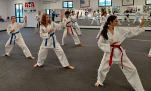 During a KFMA Family Martial Arts class, teens demonstrate the grace and power that is easily apparent in a properly executed traditional Songahm Taekwondo form.