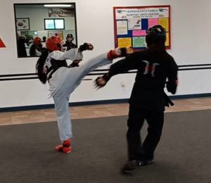 While executing a side kick during a sparring match, this teen black belt shows the importance of using self-control with her partner.