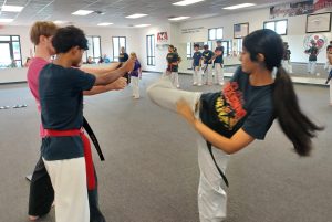 KFMA Board Breaking Tips are used by this KFMA Black Belt practicing her round kick break, which is done in combination with two other board breaks as part of her rank testings.
